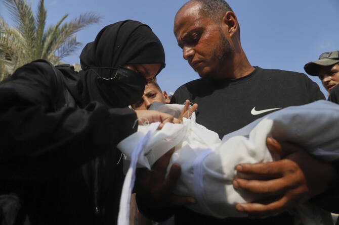 Ahmed Abu Halib and his wife Esraa Abu Halib, left, mourn over the body of their 5-month-old baby, Zainab, who died from malnutrition-related causes, during her funeral outside the Nasser Hospital, in Khan Younis, July 26, 2025. (AP)