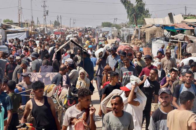 Palestinians carry humanitarian aid they received at the Rafah corridor as they walk in the Mawasi area of Rafah in the southern Gaza Strip on July 30, 2025. (Photo by AFP)