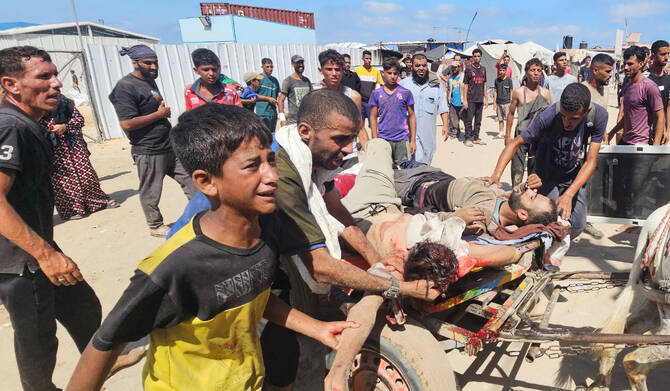 Palestinians transport victims to a clinic in Rafah after they were reportedly shot as they waited to receive food. (AFP)