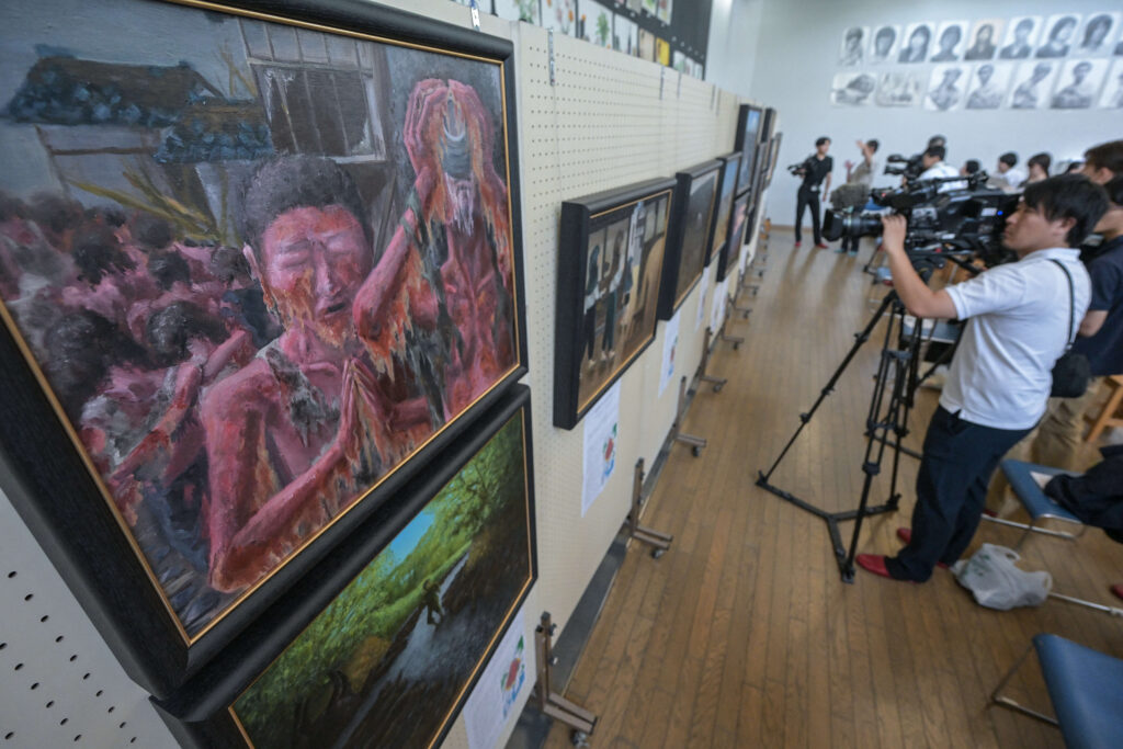 Paintings created by students through the testimonies of atomic bombing survivors to keep the memories of the 1945 bombing relevant for younger generations, at Motomachi High School in Hiroshima. (AFP)