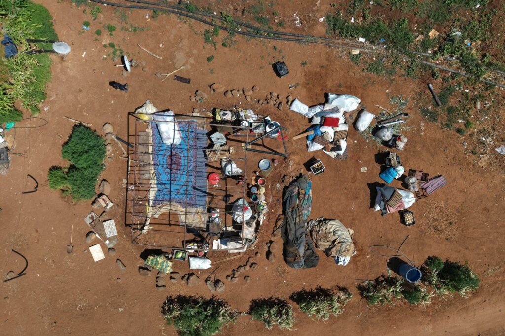 This aerial picture shows a view of Bedouin residents dismantling their camp in the vicinity of the Druze al-Mazraa village in Syria's southern Sweida gvernorate on July 17, 2025, as they prepare to leave for safer areas amid ongoing clashes. (AFP)