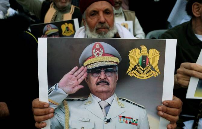 A Libyan man carries a picture of Khalifa Haftar in Benghazi, Libya, Apr. 12, 2019. (Reuters)