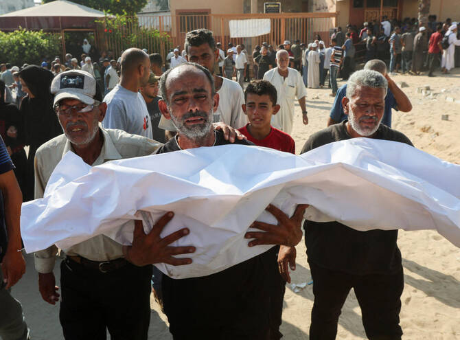 A mourner carries the body of a Palestinian killed in an overnight Israeli strike in Khan Younis in the southern Gaza Strip on July 28, 2025. (Reuters)