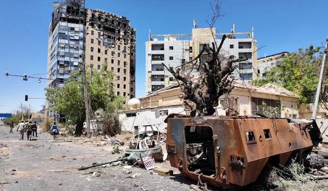 Members of army walks near a destroyed military vehicle and bombed buildings, as Sudan's army retakes ground and some displaced residents return to ravaged capital in the state of Khartoum Sudan March 26, 2025. (REUTERS)