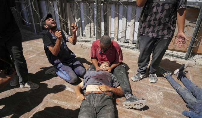 Palestinians mourn over the body of a man killed while trying to reach trucks carrying humanitarian aid en route to Gaza City, outside the Hamad Al-Qatari Hospital in Beit Lahiya, northern Gaza Strip, Friday, Aug. 1, 2025. (AP)