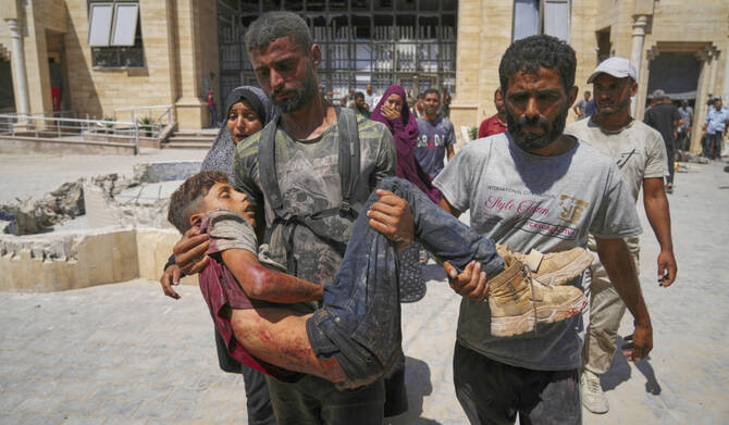 A Palestinian carries the body of a youth killed while trying to reach trucks carrying humanitarian aid en route to Gaza City, outside the Hamad Al-Qatari Hospital in Beit Lahiya, northern Gaza Strip, Friday, Aug. 1, 2025. (AP)