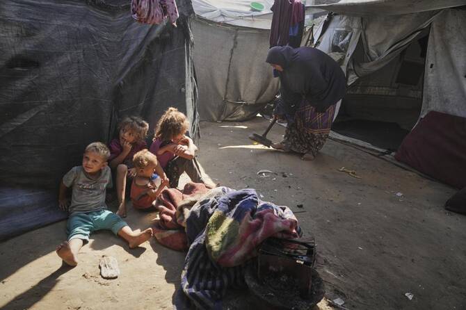 Abeer Sobh cleans her family's tent at a camp for displaced Palestinians in Gaza City on Thursday, July 24, 2025. (AP Photo/Jehad Alshrafi)