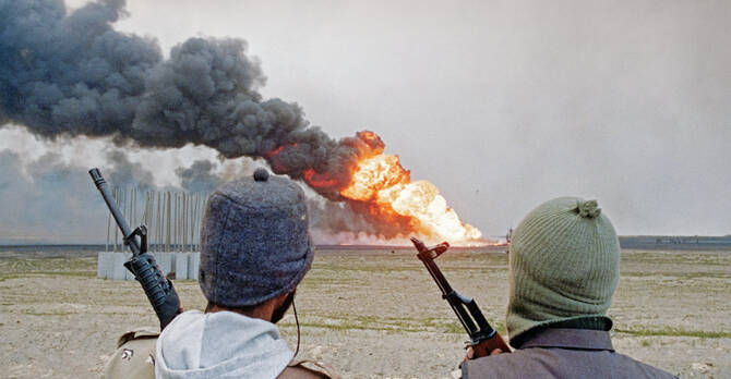 Kuwaiti soldiers watch a burning oil well as they patrol the Kuwaiti Oil Company's oil fields set on fire by Iraqi troops on March 11, 1991. (AFP File photo)