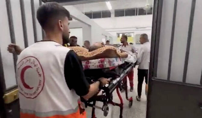 Members of the Palestine Red Crescent Society assist a Palestinian person on a stretcher, during the evacuation of people from Kamal Adwan Hospital in northern Gaza, in this screen grab taken from a handout video released on October 12, 2024. (REUTERS)