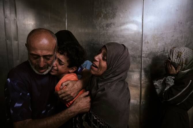Raed Salem Aslyie hugs his relatives after the death of his son at the morgue of Shifa Hospital in Gaza City. (AP)