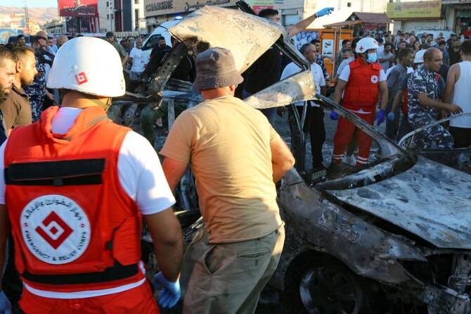 Members of the Lebanese police and rescuers check a car after it was hit by a reported Israeli strike in the Masnaa area in eastern Lebanon on Aug. 7, 2025. (AFP)