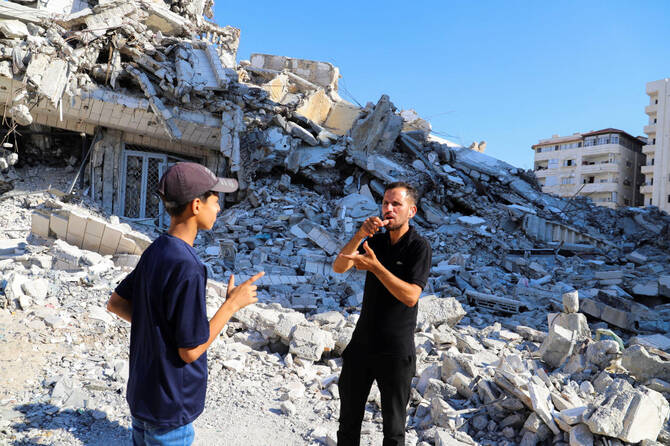 Hearing-impaired Palestinian influencer Basem Al-Habel produced images of people collecting flour from the ground while he used sign language to explain the plight of Gazans. (Reuters)