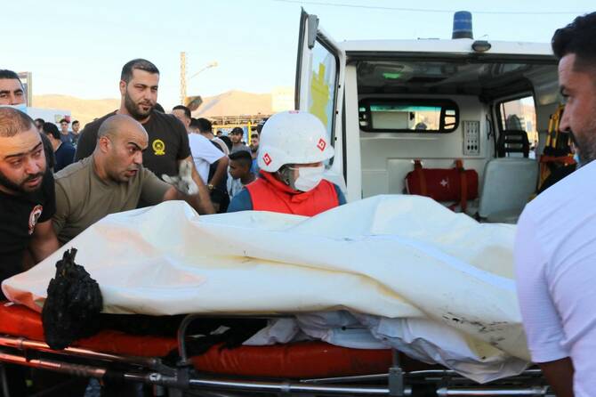 Rescuers carry a body to an ambulance after a car was hit by a reported Israeli strike in the Masnaa area in eastern Lebanon on Aug. 7, 2025. (AFP)