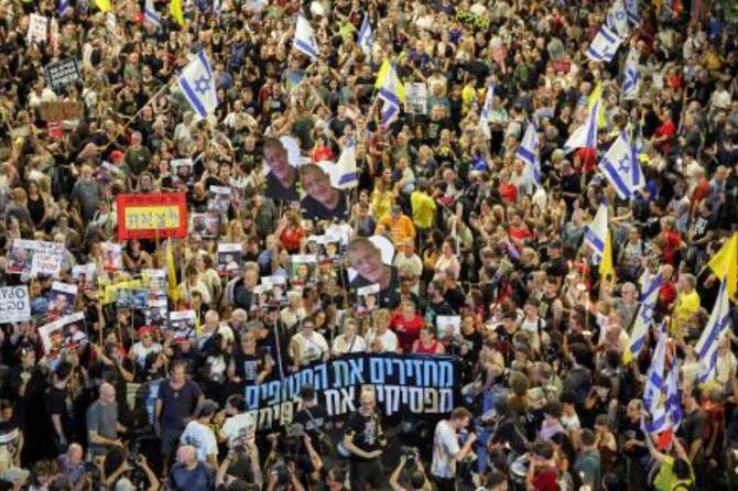 Protesters gather in a demonstration organized by the families of the Israeli hostages taken captive in Gaza since October 2023 calling for action to secure their release outside the Defense Ministry headquarters in Tel Aviv on Aug. 9, 2025. (AFP)