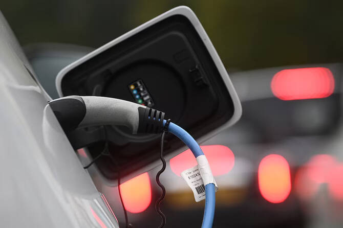 An electric car is charged at a roadside EV charge point in London, UK. File/Reuters