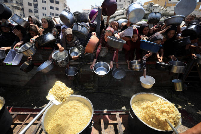 Palestinians wait to receive food from a charity kitchen in Gaza City on Friday. (Reuters)