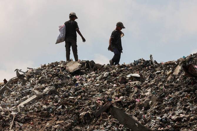 Palestinians search for things to rescue at a garbage waste dump in Gaza City on August 18, 2025. (AFP)