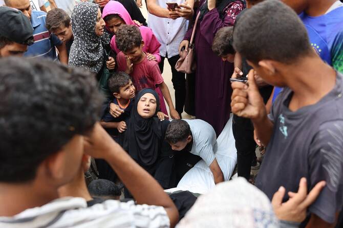 Palestinians mourn relatives, killed in Israeli strikes, ahead of their funeral at Al-Shifa hospital in Gaza City. (AFP)