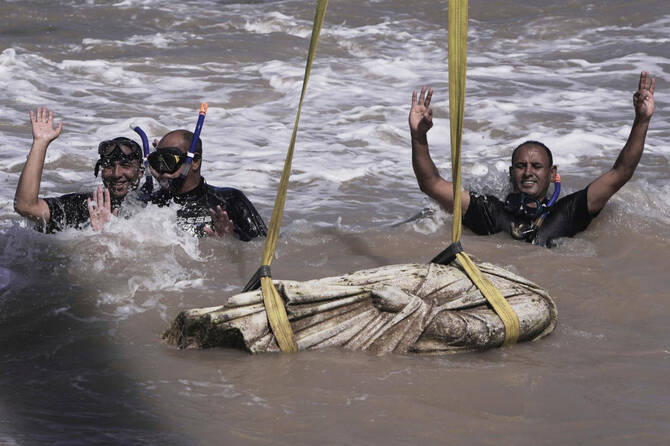 Divers celebrate after one of the ancient artifacts was lifted out of the water in Abu Qir Bay in the Mediterranean Sea city of Alexandria, Egypt, Thursday, Aug. 21, 2025. (AP)
