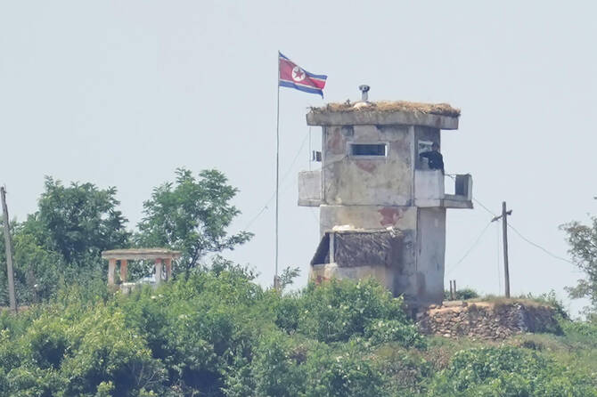 Above, a soldier stands at a North Korean military guard post flying a national flag, as seen from Paju in South Korea on June 26, 2024. (AP file photo)
