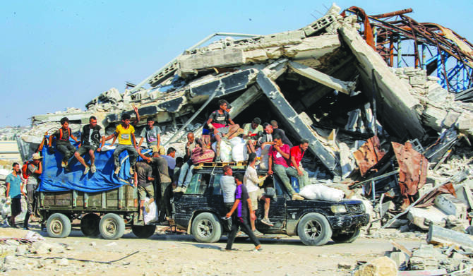 Palestinians travel with bags of humanitarian aid received at a distribution center run by the Gaza Humanitarian Foundation in the central Gaza Strip. (AFP)