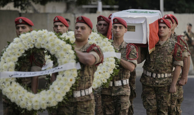 Lebanese army soldiers carry the coffin of Mohammad Shuqair, during his funeral procession in Beirut, Lebanon. (AP)