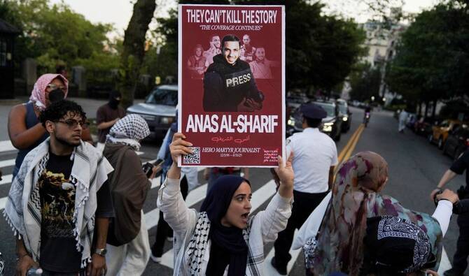 A protester holds a sign in memory of Al Jazeera correspondent Anas Al-Sharif, New York City, US, Aug. 15, 2025. (Reuters)