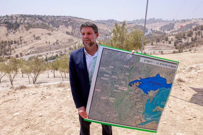 Israeli Finance Minister Bezalel Smotrich holds a map of an area near the settlement of Maale Adumim,a land corridor known as E1.