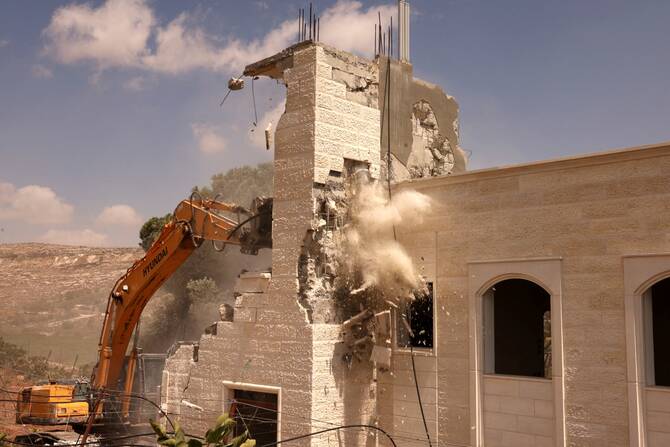 Bulldozers demolish a Palestinian house built without a permit from the Israeli authorities in Area C, which lies under Israel's military control since 1967, in Hebron in the occupied West Bank, August 29, 2023. (AFP)