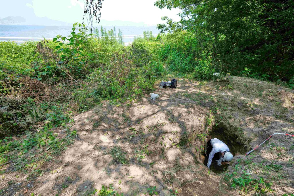 Rebun Kayo, a Hiroshima University researcher, searches for remains of victims of the 1945 Hiroshima bombing in Ninoshima in Horishima, western Japan, Tuesday, July 8, 2025. (AP Photo)