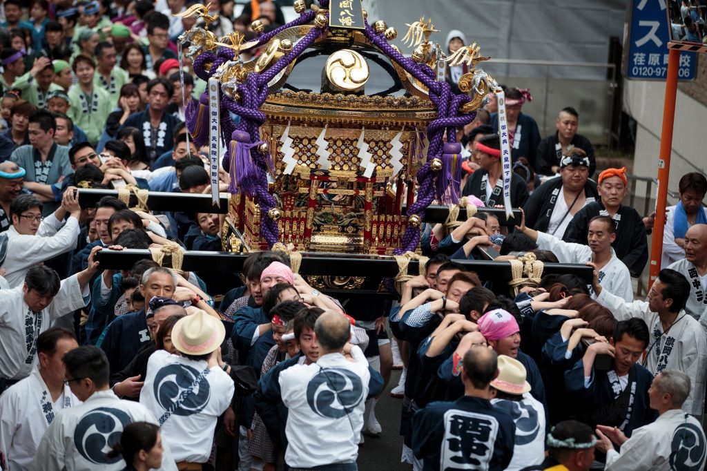2019年5月1日に東京の中延周辺で、新天皇の即位を祝う式典で、持ち運び可能な神社である「神輿」を担ぐ人々。（AFP）