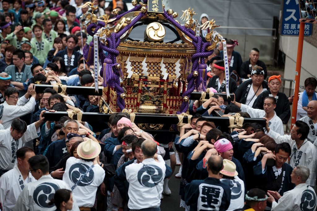 2019年5月1日に東京の中延周辺で、新天皇の即位を祝う式典で、持ち運び可能な神社である「神輿」を担ぐ人々。(AFP)