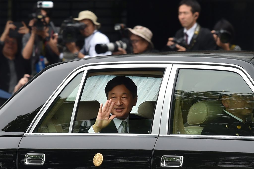 歓迎の人並みに向けて手を振られる新天皇徳仁様。皇居にて5月1日撮影。（AFP）