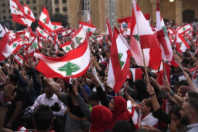 2019年10月27日首都ベイルートの中心部に位置する殉教者広場で、現在も進行中の反政府デモで国旗を振るレバノン人のデモ参加者。（AFP）