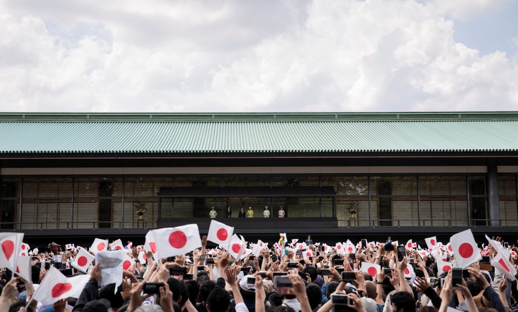 日本の徳仁天皇（中央左）と雅子皇后（中央右）が皇居での即位後、初めて公の場に現れた際、皇室支持者たちが日本の国旗を振る様子。東京、2019年5月4日（AFP）