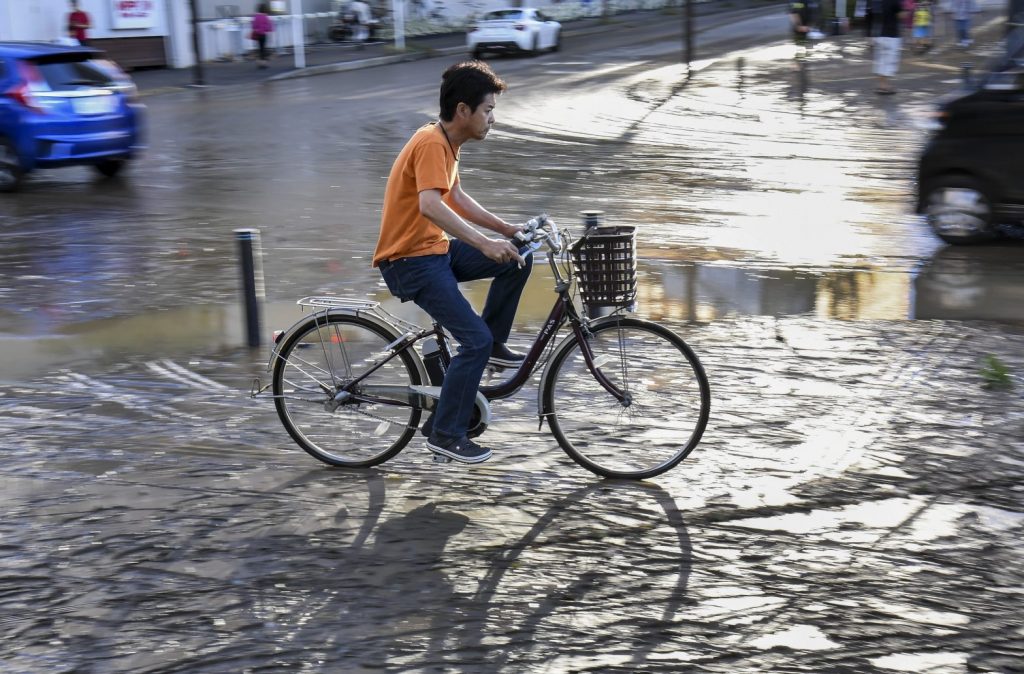 川崎市で台風ハギビスの余波の中、自転車をこいでいく男性 2019年10月31日。(ファイル写真/AFP)