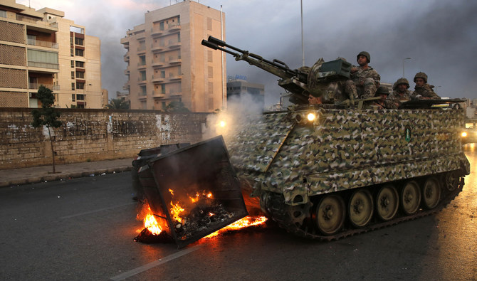 2019年10月28日の月曜日に、レバノンのベイルートで反政府デモ参加者の手によって発火したゴミ容器を撤去する陸軍の装甲兵員輸送車。(AFP通信)