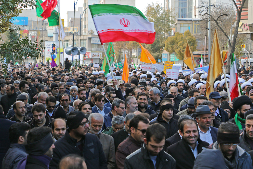 北西部の都市、アルダビールでの抗議活動中に国旗を振るイランの人たち。（AFP）