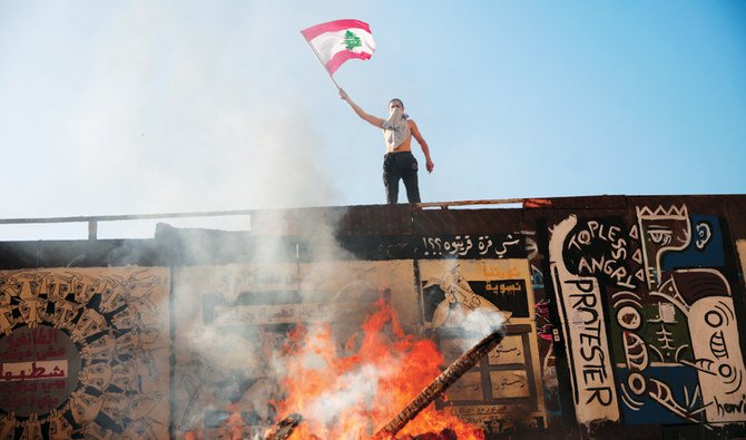 ベイルートでの抗議活動中にレバノンの国旗を振る抗議活動参加者。（ロイター通信）