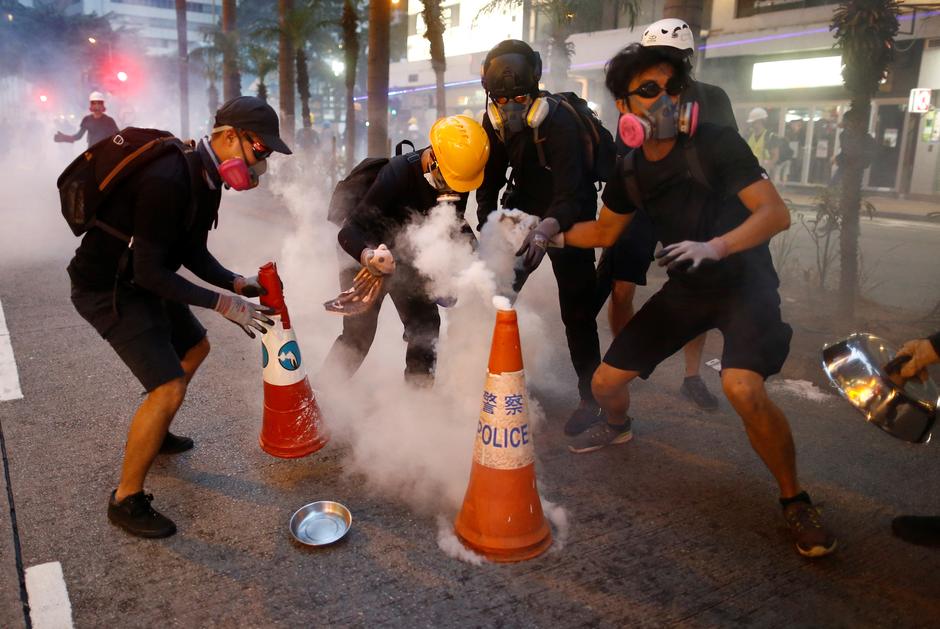 香港の湾仔でのデモ中に催涙ガス弾を消火しようとする、身柄引き渡し法案に反対する抗議活動参加者。（『ロイター通信』）