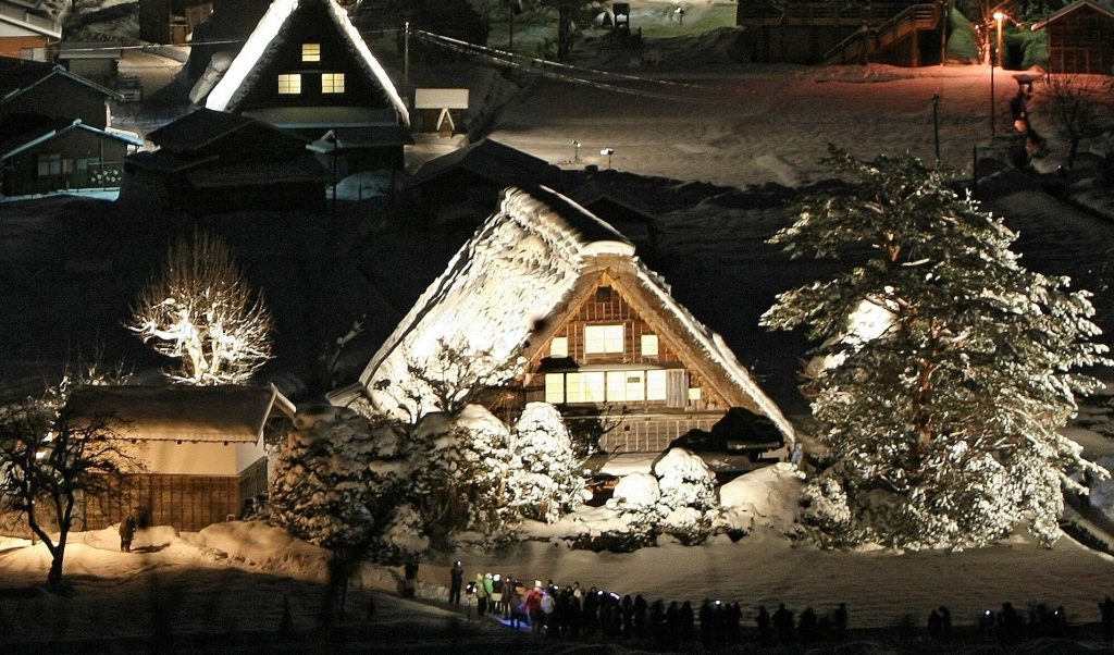 東京のおよそ270km西に位置する岐阜県白川郷で雪の中ライトアップされる日本の伝統的な様式、「合掌造り」で建てられた家々。2009年1月24日撮影。（AFP/時事通信社） 