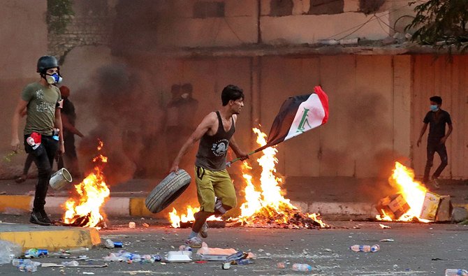 反政府デモでは、治安部隊が実弾と催涙弾を発射するなか炎が上がった。イラク・バグダッドの国営テレビ局付近にて＝2019年11月4日月曜日（AP通信）
