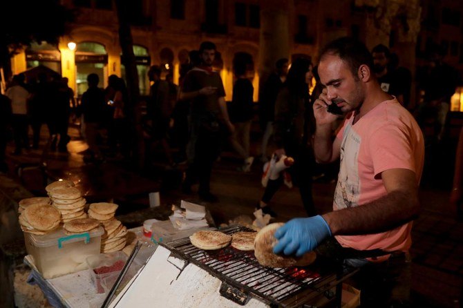 ベイルート中心街での反政府デモの最中に、香りの良いパンを調理する露天商。（AFP）