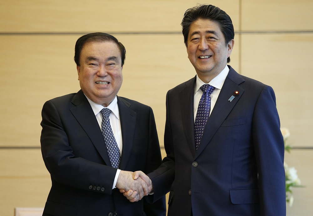 2017年5月18日、日本の安倍晋三首相と東京の首相公邸で握手する韓国の大統領特別公使の文喜相氏(左)。(AFP/file)