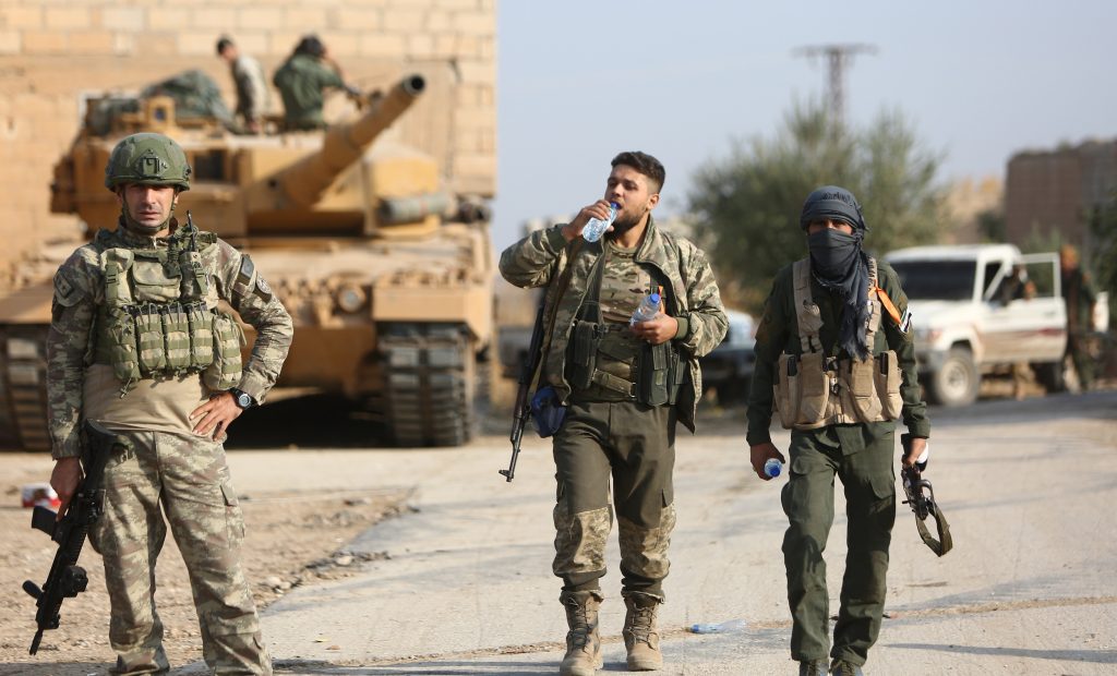 2019年10月28日、シリア北東部のラス・アルアインの東にある村を急襲中に歩くトルコの兵隊たちとトルコが支援するシリア人兵士。（AFP）
