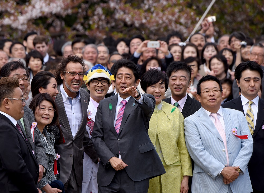 首相主催で2017年4月5日に開催された「桜を見る会」で芸能人、スポーツ選手らと写真に収まる日本の安倍晋三首相と昭恵夫人。(AFP/ファイル)