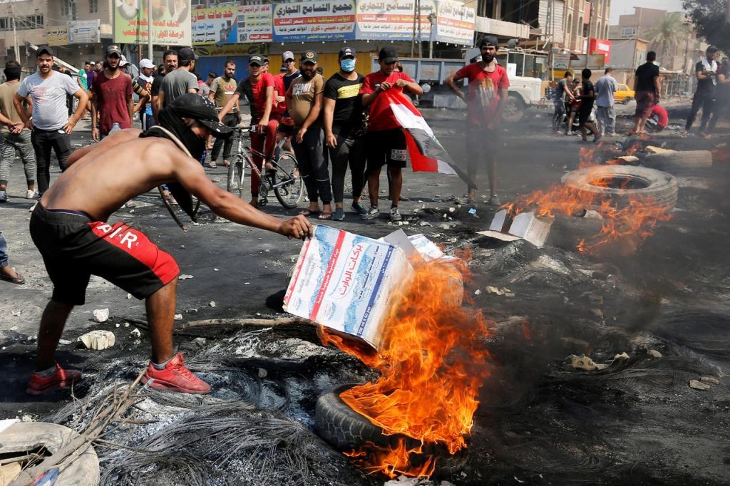 バグダッドでの反政府デモでタイヤを燃やす参加者ら（ロイター）