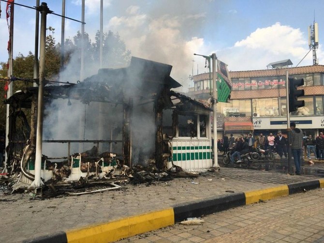 デモ隊によって放火され黒焦となった警察署の周りに集るイラン人たち。(ファイル/ AFP)