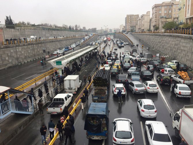 2：2019年11月16日、イランのテヘランで、幹線道路上で車を停め、ガソリン価格の上昇に抗議する人々。（ロイター通信）