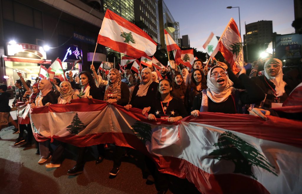 ベイルート中心部で続く反政府デモに参加し国旗を掲げるレバノン首都の人々 (2019年11月30日)。かつてない規模の反政府デモが1か月以上続くレバノンは政治経済両面の危機に瀕している。(AFP)